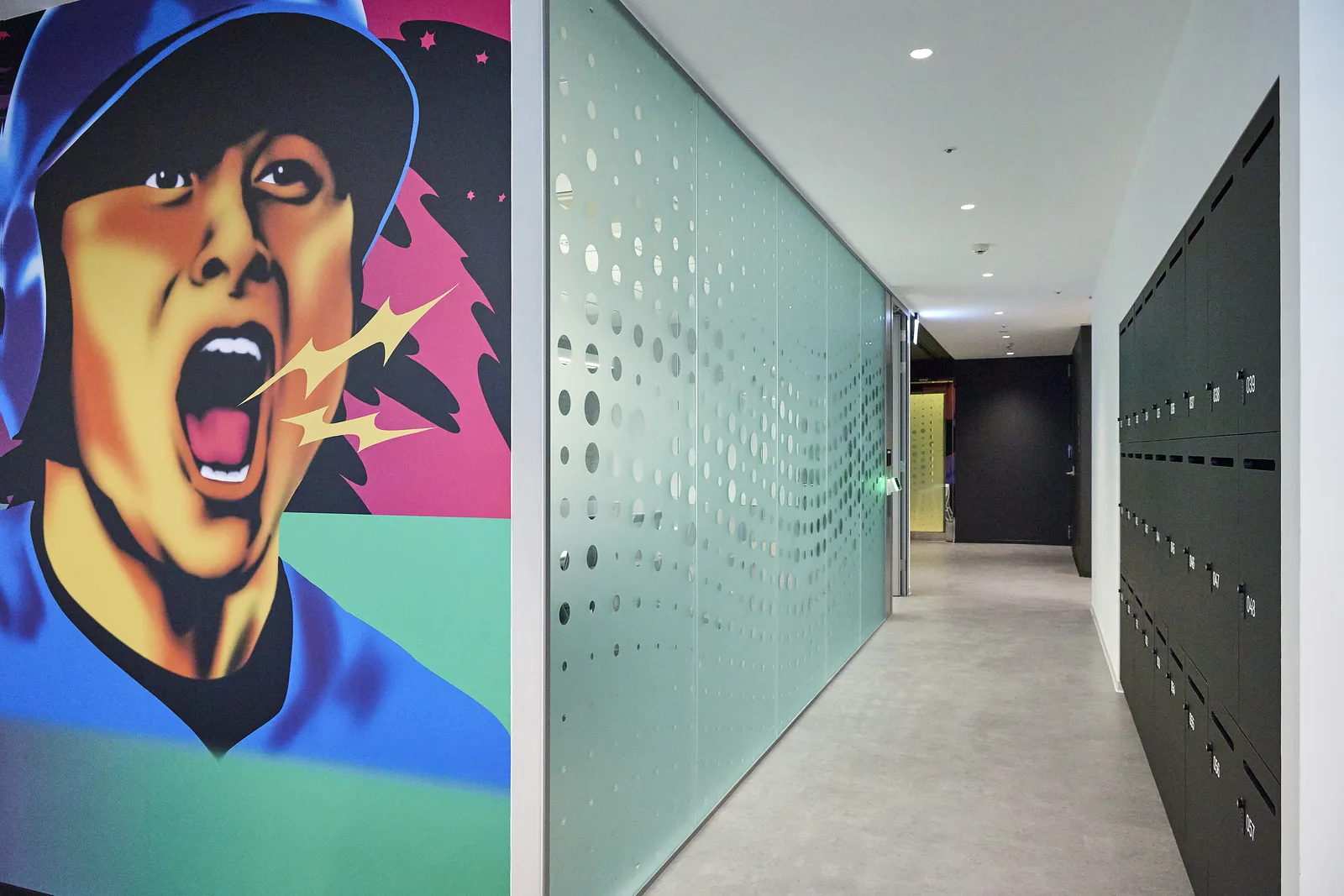 Office corridor combining brand graphics with glass partitions